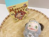 a small stuffed animal sitting on a tray next to a box of cereal