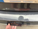 a person holding a ruler in front of a car
