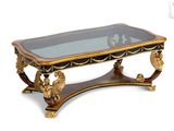 une table basse avec un plateau en verre et des motifs dorés