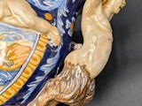 a blue and yellow vase with a lion on it
