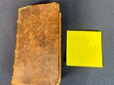 un vieux livre posé sur une table, à côté d'un post-it jaune