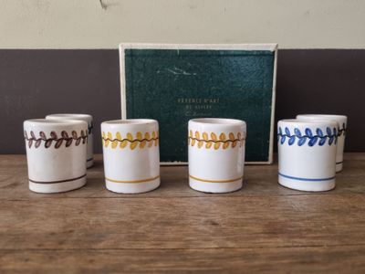 four white and blue coffee cups sitting on top of a wooden table