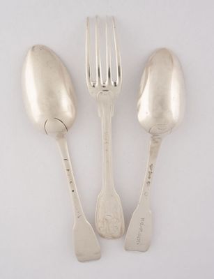 trois cuillères et une fourchette en argent sur une surface blanche