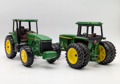 two toy tractors that are sitting next to each other