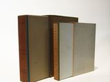three books are stacked on top of each other on a white surface