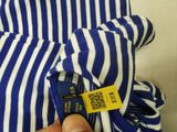 a person holding a blue and white striped shirt with a qr code attached to it