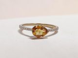 an image of a yellow and white diamond ring on a white surface