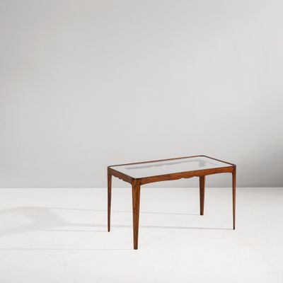 une table avec un plateau en verre posée sur un meuble blanc