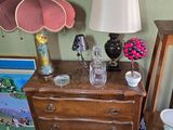 a dresser with a lamp on top of it in a room