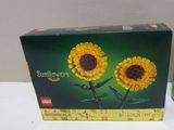une boîte de tournesols en Lego posée sur une table