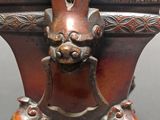 a small wooden table with a lion head on top of it
