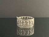a silver bracelet that is sitting on a table
