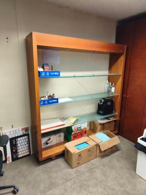 a room with a desk, shelves, and a printer in it