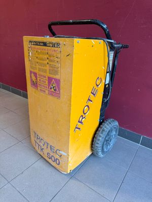 une grande boîte jaune posée par terre près d'un mur rouge