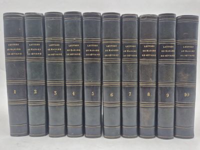 six old books are lined up in a row on a white surface