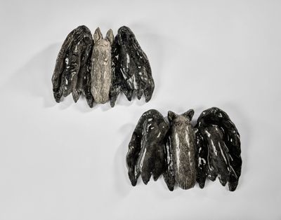 deux pièces de métal noir et argenté sur une surface blanche