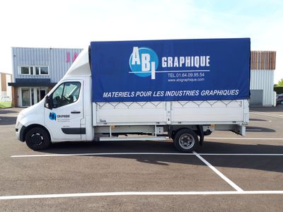 un camion garé sur un parking, avec une pancarte à l'arrière