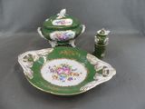 a green and white plate with a bowl and a candle holder