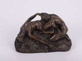 statue en bronze représentant un homme et une femme en train de lutter sur un rocher