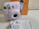 an image of a purple camera sitting on top of a table next to a box