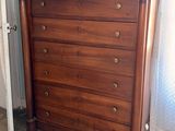 a wooden chest of drawers in the corner of a room
