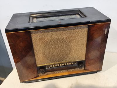 une vieille radio posée sur une table près d'un mur blanc