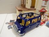 a blue toy bus with teddy bears in the back