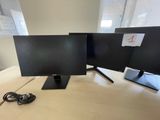 two computer monitors sitting on top of a wooden desk next to each other