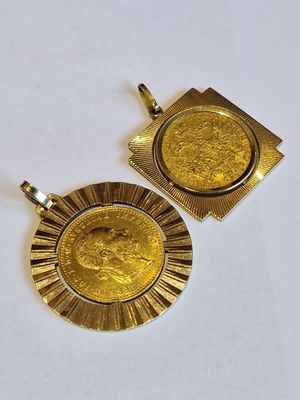 deux pendentifs en forme de pièces d'or sur une surface blanche, avec un fond blanc