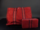 un sac et un portefeuille à rayures rouges et noires posés sur une surface noire