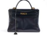 un sac à main en cuir noir avec des ferrures dorées sur la poignée