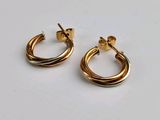 deux boucles d'oreilles en anneau dorées sur un fond blanc