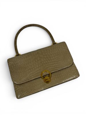 an image of a brown purse with a gold ring on the handle