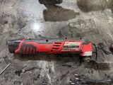 a red corded drill on the floor next to other tools