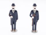 two figurines of a man in a suit and hat