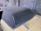 an old car with a sunroof sitting in a garage