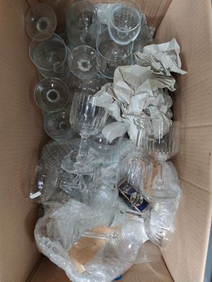 a cardboard box full of empty wine glasses and other items