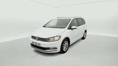 La Volkswagen Touran blanche est garée dans une pièce blanche.