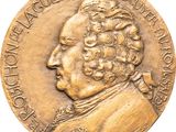 an image of a gold medal with a man ' s face on it