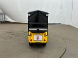 a small yellow cart with a black top on a cement floor