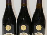 trois bouteilles de vin posées sur une table, l'une à côté de l'autre