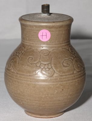 un vase marron sur lequel est collé un autocollant rose