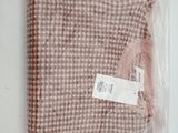the pink sweater is wrapped in plastic on a white surface