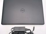dell laptop computer with power cord and charger sitting on a white surface