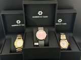 three watches in a black box on a black surface