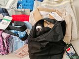 a pile of clothes and a bag on a table