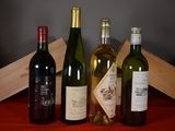 several bottles of wine are lined up on a red table