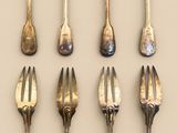 a lot of forks and spoons that are on the table