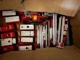 a cardboard box filled with toy fire trucks and ladders