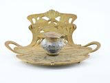 a gold plate with a silver vase on it
